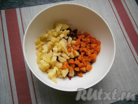 Морковку с картофелем тоже нарезать на небольшие кубики, а затем выложить к свекле, смешанной с маслом.