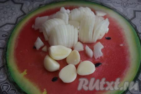 Очистим лук и чеснок от кожицы, а затем нарежем луковицу на четверть кольца, а зубчики чеснока - на пластины.