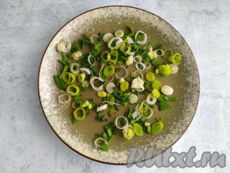 Зелёный лук и чеснок промыть в проточной воде, обсушить в полотенце, нарезать. На тарелку для подачи выложить подушку из нарезанной зелени.