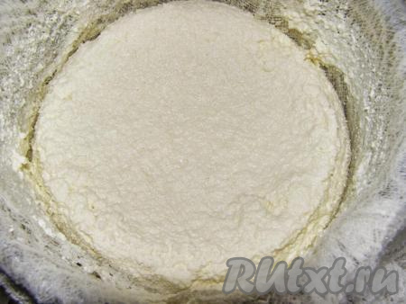 Дуршлаг застилаем марлей в 3 слоя и переливаем туда полученную творожную массу. Сыворотку можно вылить, а можно оставить, чтобы потом приготовить на ней оладьи, блины или другую выпечку. Сворачиваем концы марли и подвешиваем над раковиной (или кастрюлей), чтобы оставшаяся сыворотка стекла. Можно положить в ёмкость и придавить прессом, например, плоской тарелкой и банкой с водой. Оставляем на 7-8 часов.