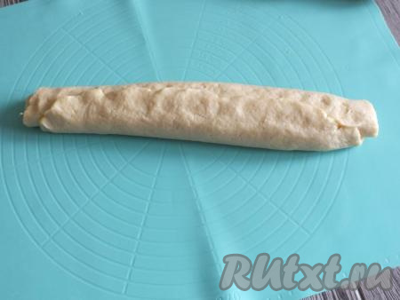 Начиная с широкой стороны пласта, сверните тесто в рулет. Место шва скрепите.