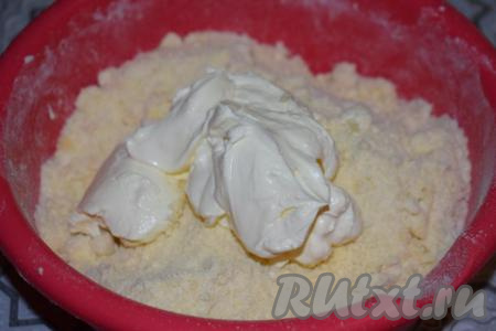 К крошке выкладываем сметану и начинаем замешивать тесто.