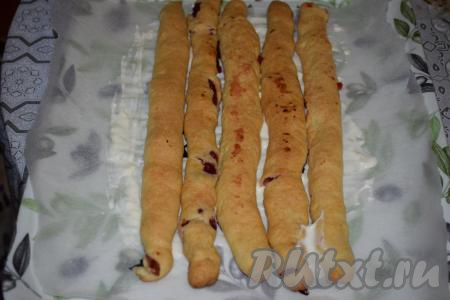 Застилаем поднос пергаментом и смазываем пергамент кремом для того, чтобы трубочки-брёвнышки надёжно закрепились. На нижний ярус кладём 5 трубочек. Более ровные и красивые трубочки выкладываем по краям, они будут видны, а более неровные - в центр.&nbsp;