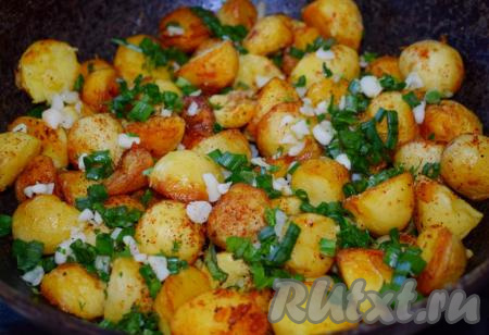 Добавляем измельчённую зелень к жареному картофелю, перемешиваем, накрываем крышкой и готовим ещё 2 минуты.