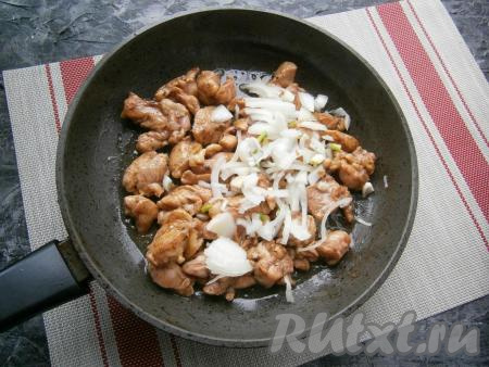 Кусочки замаринованной курицы обжарить на растительном масле на среднем огне до румяности со всех сторон, помешивая время от времени, затем добавить очищенный и нарезанный полукольцами репчатый лук.