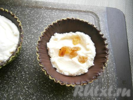 По прошествии времени достать силиконовые&nbsp;формочки из холодильника и разложить в каждую&nbsp;формочку творожную массу (до половины высоты формы), в серединке разместить по несколько ягод изюма (или других ягодок, или орехов, можно и вовсе ничего не добавлять).