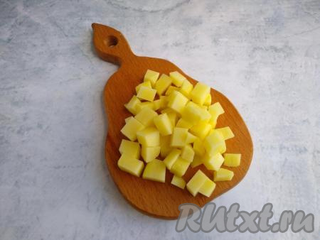 Очистить картофель  от кожуры, нарезать на кубики с размером стороны 0,8-1 см. Промыть нарезанную картошку в проточной воде, выложить в кастрюлю. Залить картофель 1,5 литрами холодной водой, довести воду до кипения на сильном огне, затем убрать пену и варить на среднем огне 5 минут.