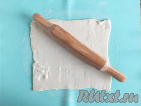 Займитесь тестом. Рабочую поверхность присыпьте 0,5 столовой ложки муки. Раскатайте 1 часть теста&nbsp;в пласт толщиной 0,5 см, ориентировочно размером 30 см на 20 см. Подобным образом раскатайте и вторую часть теста.