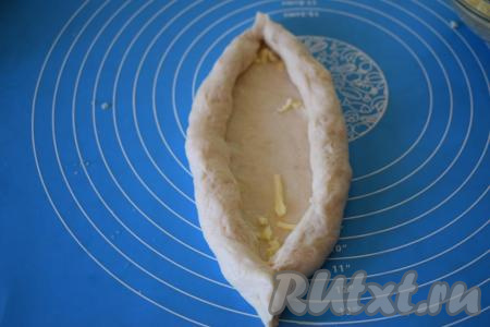 Слепляем края свёрнутого теста, образуя лодочку.