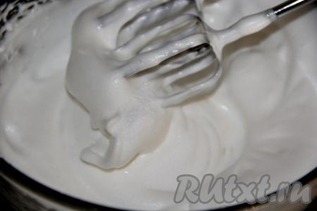 Взбивать белки с сахарной пудрой до стойких пиков.