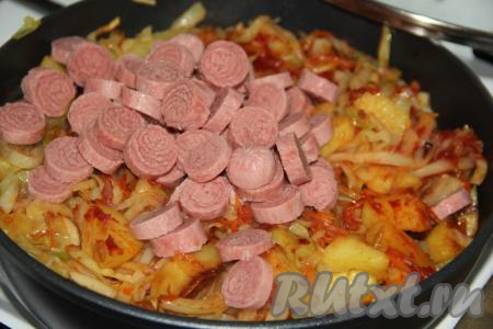 Сосиски, очищенные от слюды, нарезать на кружочки (я использовала замороженные сосиски, предварительно их не размораживала) и тоже добавить в сковороду.