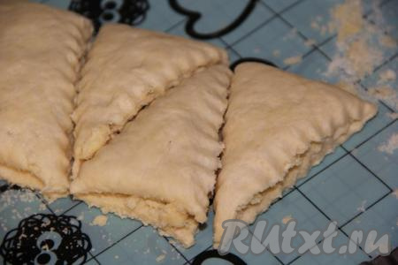 Нарезать рулет на треугольники (или полоски). Таким же образом сделать треугольники из второго пласта теста.