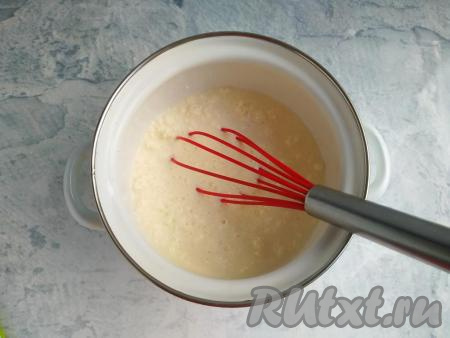 В кастрюлю влить молоко, добавить творог, перемешать массу венчиком.