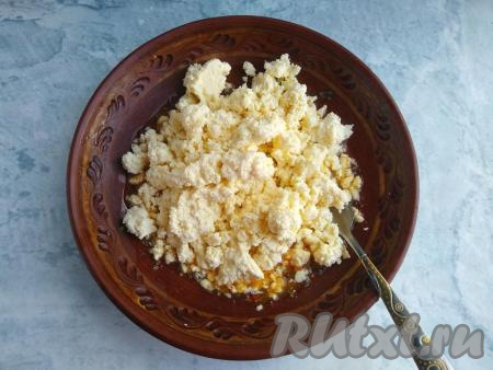 К смеси масла, яйца, соды и специй добавить творожную массу, тщательно растереть получившуюся массу вилкой.