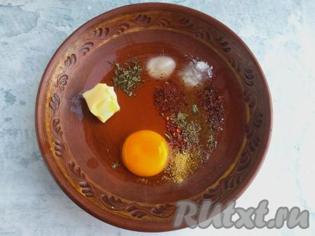В миску выложить яйцо, соль, соду, специи и размягчённое сливочное масло (для того чтобы масло размягчилось, его нужно заранее достать из холодильника), перемешать.