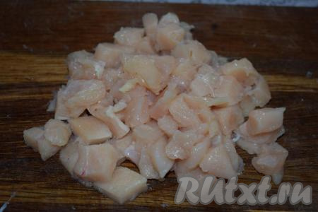 Далее нарезаем на мелкие кубики куриную грудку. Солим и перчим куриное мясо, добавляем специи по вкусу.