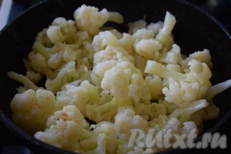 К обжаренному луку добавляем отваренную цветную капусту и слегка обжариваем её на среднем огне (минуты 3-4), аккуратно перемешивая время от времени.