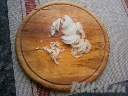 Небольшой репчатый лук почистить, а затем нарезать тонкими полукольцами, очищенный зубчик чеснока измельчить ножом.