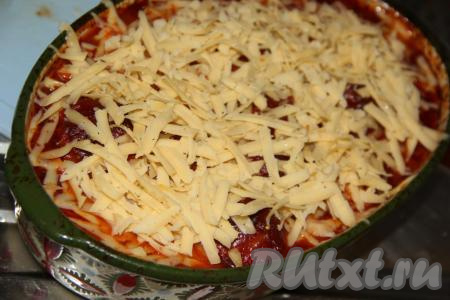 Поставить форму с фрикадельками в томатно-сметанном соусе в разогретую духовку и запекать минут 10 при температуре 200 градусов. Затем достать форму, посыпать фрикадельки тёртым сыром.