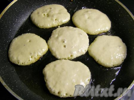 В сковородку наливаем масло (примерно, 1 столовую ложку) и сильно нагреваем. Когда масло будет горячим, столовой ложкой выкладываем в него тесто, формируя оладушки. Обжариваем около минуты на среднем огне, пока тесто сверху слегка не потемнеет и не появятся небольшие пузырьки.