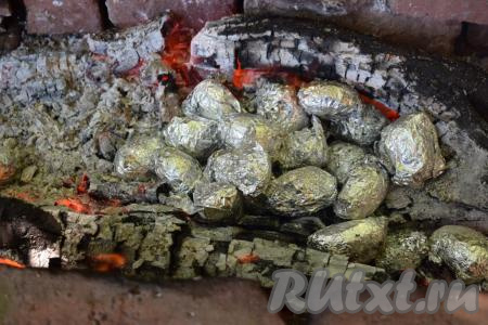 Разводим костёр, ждём, пока все дрова прогорят и останутся только горячие угли без открытого пламени. Кладём молодую картошку, завёрнутую в фольгу, на угли и засыпаем углями сверху.