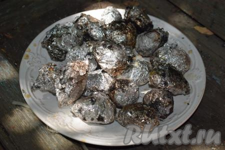 Запечённый молодой картофель вынимаем из углей и складываем на тарелку.