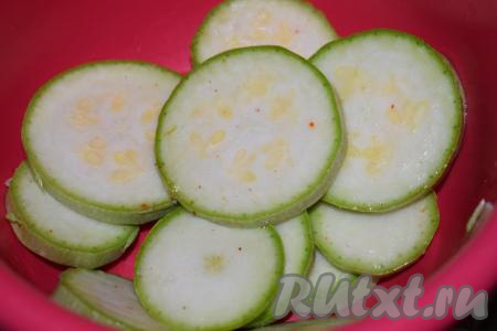 Кабачки с тонкой кожицей можно готовить, не очищая от кожуры. Молодые кабачки нарежем на кружочки толщиной 7-8 мм, выложим в миску, посолим их по вкусу и оставим постоять на минут 10. За это время кабачки просолятся и пустят сок. Сок сливаем и слегка промакиваем кабачки бумажными полотенцами.