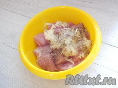 Очистите лук и чеснок. Лук натрите на крупной тёрке, чеснок - на мелкой тёрке и выложите в миску к куриному филе, добавьте специи по вкусу.