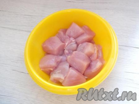 Вымойте куриное филе, обсушите бумажным полотенцем, а затем нарежьте на кусочки размером 3 см на 3 см и переложите в миску.