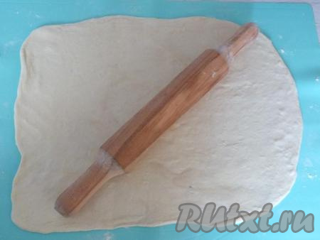 Рабочую поверхность подпылите мукой. Разложите на неё размороженное слоёное бездрожжевое тесто и раскатайте в тонкий пласт толщиной около 0,5 см. Я раскатываю по размеру своего противня (30 см на 36 см).