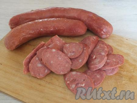 Подготовьте начинку для пиццы. Колбасу нарежьте тонкими (ориентировочно толщиной около 3 мм) кругляшками, можно нарезать и продолговатыми кусочками - выбирайте на свой вкус.