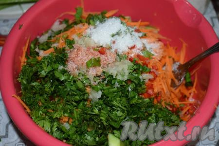 В миску к огурцам и моркови выкладываем измельчённую зелень и зелёный лук, острый перец и чеснок, солим и добавляем сахар.