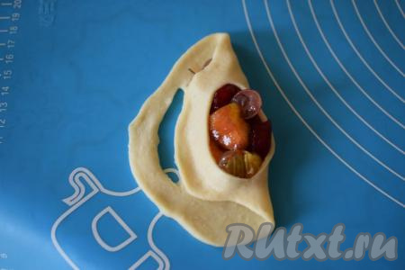 Затем перекидываем правую полосу к левой стороне пирожка и прижимаем пальцами. Далее левую полосу перекидываем на правую сторону, кончики плотно слепляем пальцами.