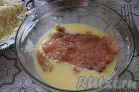 Берём отбивную из куриного филе и окунаем её в кляр так, чтобы мясо было покрыто кляром со всех сторон.