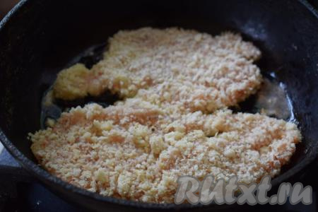 Далее разогреваем сковороду и вливаем в неё растительное масло. Опускаем в разогретое масло шницели из куриного филе, обжариваем их на среднем огне минут 10 сначала с одной стороны.