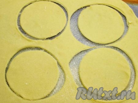 Для удобства делим тесто на несколько частей, доску для раскатывания теста посыпаем мукой и тонко раскатываем тесто. Его толщина не должна быть более 1 мм. Стаканом (или круглой формочкой) вырезаем кружочки диаметром, примерно, 6-7 см.