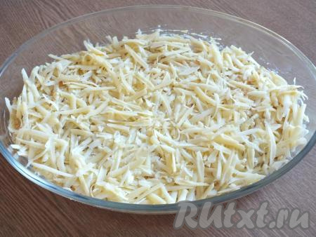 Натрите сыр на крупной тёрке и равномерно разложите поверх сметанного соуса. Поставьте форму с минтаем под соусом в разогретую до 180 градусов духовку и запекайте минут 25-30.