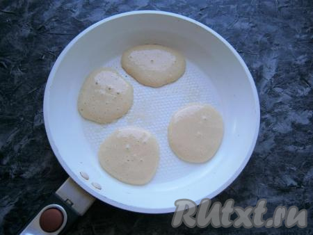 Сковороду смазать небольшим количеством сливочного масла, нагреть её. Выкладывать тесто на горячую сковороду столовой ложкой в виде небольших оладушек.