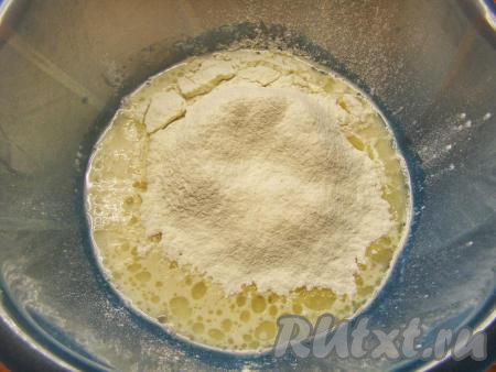 Всыпаем немного просеянной муки. Перемешиваем сначала столовой ложкой, подсыпаем ещё муку по частям. Когда перемешивать ложкой станет тяжело, замешиваем тесто руками.