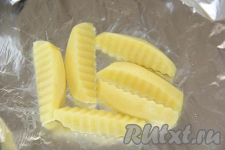 Картофель почистить и нарезать крупными дольками. На кусок фольги выложить несколько долек картофеля. Я картофель не солила, во время приготовления он пропитался маринадом от курицы.