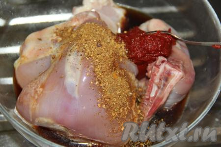 К куриным бёдрам добавить соль, томатную пасту и специи (можно взять любые специи).
