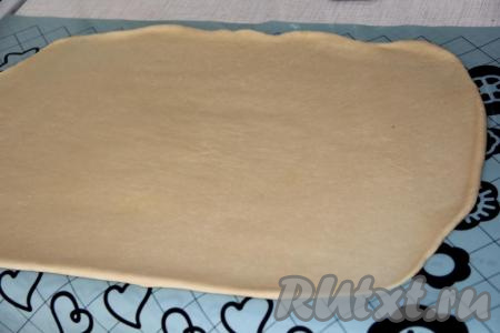 Раскатать тесто скалкой в пласт прямоугольной формы длиной, примерно, 60 см.