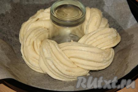 Противень застелить пергаментом и смазать маслом, можно использовать тефлоновый коврик. Выложить косу на противень и сформировать кольцо. Я в серединку поставила толстостенный стакан, чтобы плетёнка была ровной. Хорошо скрепить край. Оставить сдобную плетёнку для расстойки на 45 минут.