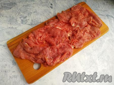 Говядину нарезать поперёк волокон толщиной около 0,7 см, накрыть пищевой плёнкой и отбить.