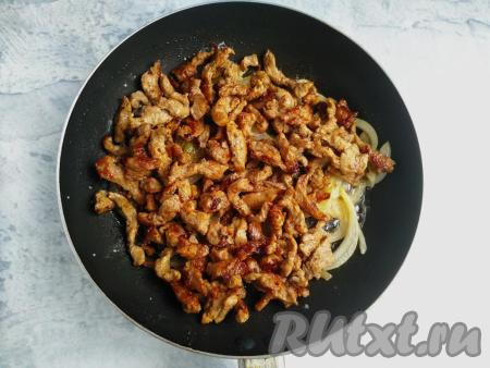 Добавить подготовленную говядину, перемешать, обжарить вместе с луком на среднем огне до зарумянивания мяса, не забывая иногда перемешивать.