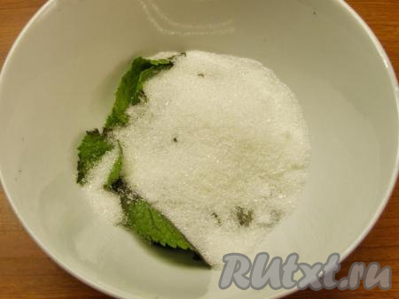 Мяту хорошо моем в проточной воде, слегка просушиваем полотенцем и отрываем листочки от веточек. Перекладываем листочки в ёмкость, добавляем 50 грамм сахара и измельчаем блендером, пока не получится кашица. Отставляем сахарно-мятную смесь в сторону, она нам понадобится в конце.