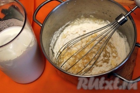 Добавьте к взбитым желткам муку с разрыхлителем, растительное масло и тщательно перемешайте венчиком (или миксером).