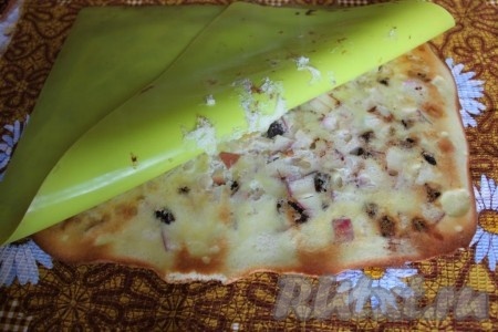 Испечённый бисквит с яблоками&nbsp;переверните на полотенце из ткани, уберите коврик (или бумагу для выпечки). Прямо в тёплом виде аккуратно сверните бисквит в рулет.