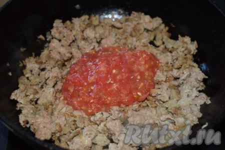К фаршу, обжаренному с луком, добавляем натёртые помидоры, перемешиваем.