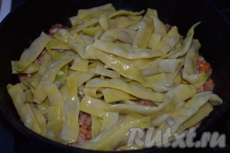 Добавляем в сковороду отваренную фасоль, соль, специи, перемешиваем и накрываем сковороду крышкой.